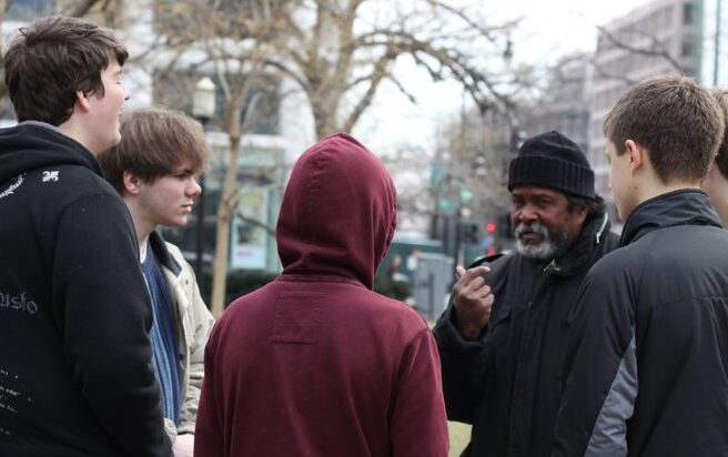 Youth talking with homeless man